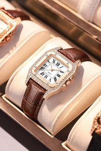Detail of square rose gold watch with crystal bezel and brown leather alligator strap
