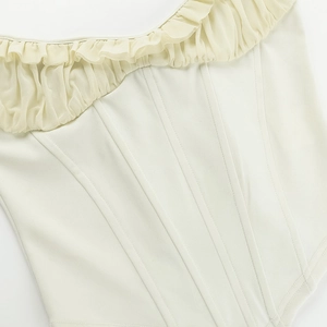 Detail of off-white corset top with chiffon ruffled neckline and stitch texture