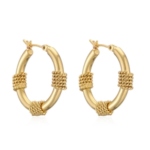 Close-up of gold-plated C-shaped hoop earrings with intertwined wire texture details