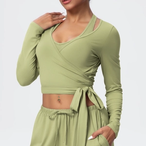 Detail of sage green yoga set showing wrap tie-front long sleeve top and jogger pants