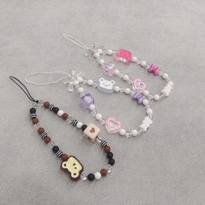 Detailed view of three beaded phone charms with acrylic bears and cute ribbon bows