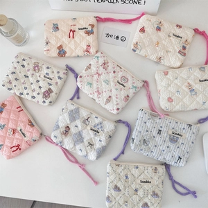 Flat lay of small floral quilted cotton pouches with zippers and braided wrist straps