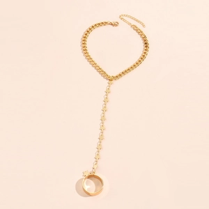 Detail view of a gold chain ring bracelet with multiple star-shaped charms and wide band