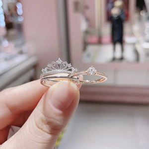 Two-in-one silver crown and rose gold diamond ring set held for detailed showcase