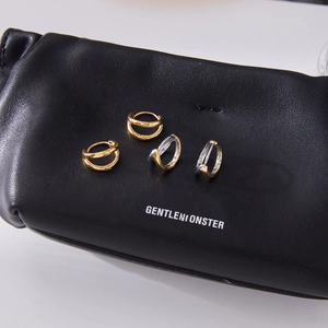 Classic 18K gold stainless steel hollow hoop earrings displayed on black leather