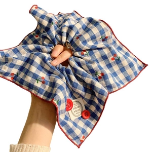 Blue and white plaid scrunchie with cherry print and decorative button on wrist