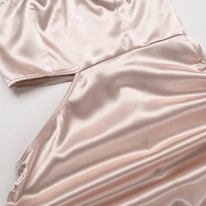 Gros plan détaillé de la robe en satin rose champagne montrant la texture et la découpe