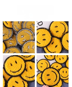 Macro shot of yellow chenille smiley face patches with black embroidered edges and texture