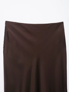 Detail of high-waist dark brown satin skirt featuring smooth silk texture and hidden zipper