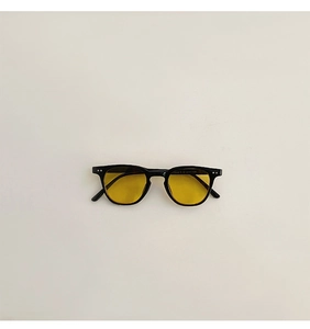 Détail de lunettes de soleil carrées noires pour enfants avec verres jaunes rétro