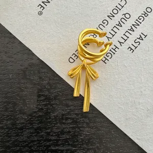 Detailed close-up of a vintage-style golden butterfly ear cuff on a textured background
