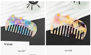 Close-up of cat-shaped acetate hair combs with wide teeth and glitter gold foil details