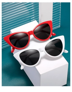 Close-up of red and white cat-eye sunglasses with black lenses on geometric blocks