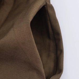 Close-up of high-quality brown poplin fabric with neat stitching on pocket detail
