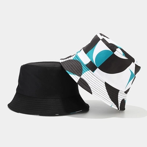 Detailansicht von modischen, doppelseitigen Fischerhüten in Schwarz und geometrischem Print.