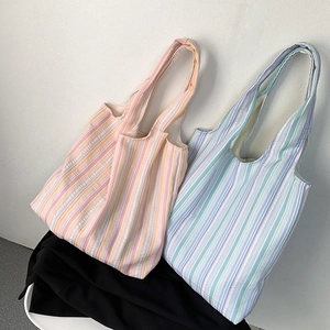 Détail montrant des sacs cabas en toile à rayures colorées en rose et bleu