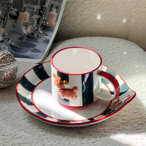 Detailed view of hand-painted ceramic coffee cup with red-green stripes and dog relief