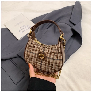 Détail du mini sac hobo avec tissu à carreaux marron, chaîne dorée et poignée en similicuir