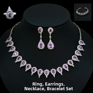 Detail of luxury bridal jewelry set with purple teardrop stones and micro-pave crystals