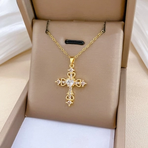 Macro view of gold cross necklace with hollow pattern and heart zircon in jewelry box