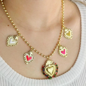 Collana bohémien con perline dorate e ciondoli a cuore colorati su una modella