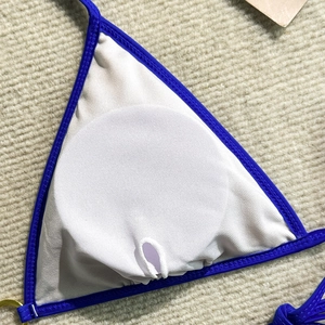 Detail of bikini top showing the removable padding slot and blue lace trim design