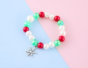 Makro-Detail des Weihnachts-Perlenarmbands mit roten Perlen und Silber-Schneeflocke