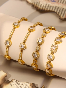 Close-up of four 18K gold PVD coated stainless steel bracelets with geometric zircons