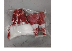 Detail of luminous Christmas gnome doll with red knitted hat and plush legs in packaging