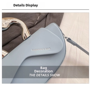Gros plan détaillé du sac selle bleu clair avec poignée en métal argenté et cuir lisse