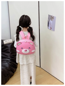 Pink cartoon bear hard shell backpack for girls shown from behind on a child model