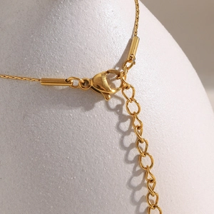 Close-up of 18K gold plated lobster clasp and adjustable extender chain link on necklace