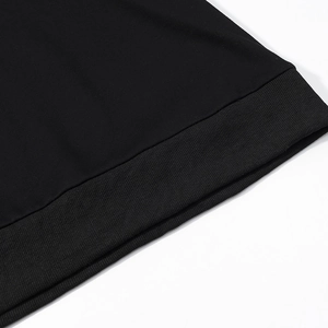Close-up of black ribbed knit hem and texture on a casual hooded sweatshirt