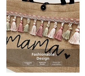 Close-up of woven jute tote bag with colorful tassels and black mama print detail