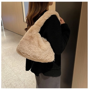 Close-up of plush faux fur shoulder bag worn by a model in a modern interior setting