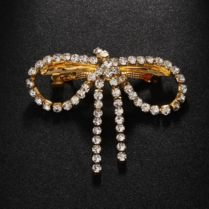 Detailed close-up of golden metal butterfly hair clip with sparkling rhinestones decoration