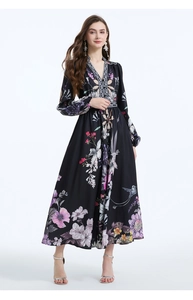 Detail of floral printed maxi dress featuring deep V-neck and cinched waist on black fabric