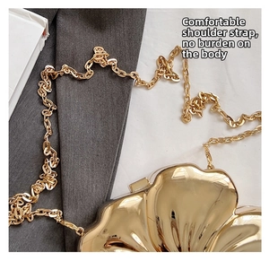 Close-up of golden petal-shaped metallic evening bag with polished finish and chain strap