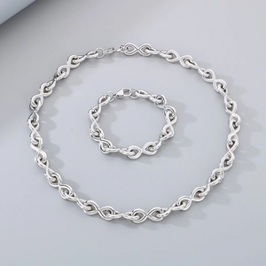 Polished silver infinity link jewelry set with necklace and bracelet on gray backdrop