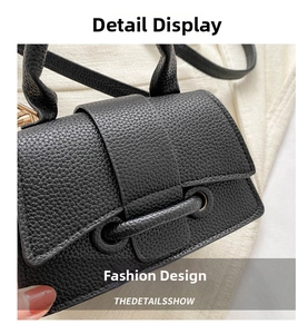 Close-up of black litchi pattern leather texture with gold metal buckle detail