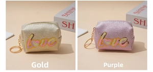 Detail of glitter sequin mini pouches in gold and purple with love embroidery and keychain