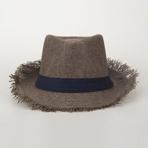 Détail du bord effiloché et du ruban bleu d'un chapeau de paille tressé d'été