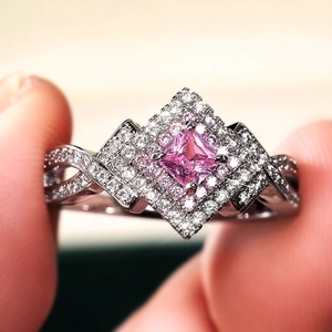 Macro view of criss-cross ring with princess cut pink zircon and halo diamonds