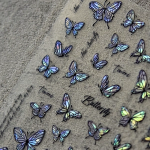 Macro shot of laser iridescent butterfly nail stickers with blue-purple metallic finish