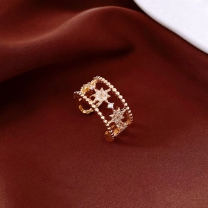 Macro shot of gold-plated star patterned hollow ring with zircon inlay on velvet