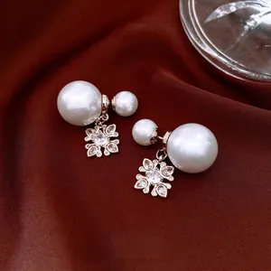 French vintage pearl drop earrings with zircon floral accents on dark red satin