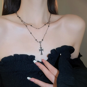Dettaglio della collana a doppio strato in argento con croce nera sulla modella