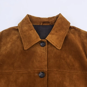 Gros plan du revers d'une veste en daim marron avec coutures et boutons noirs