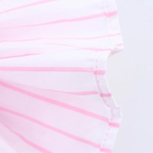 Close-up of pink and white striped fabric texture with fine stitching on dress detail