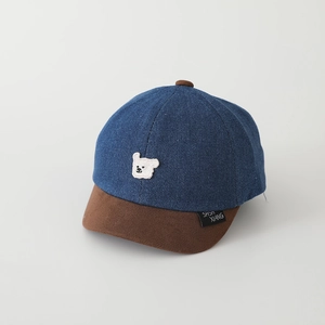 Dettaglio del cappellino bimbo in denim bicolore con ricamo di orsetto peluche